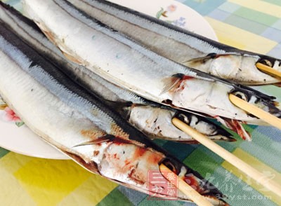 烤盤上鋪上錫箔紙，秋刀魚劃刀