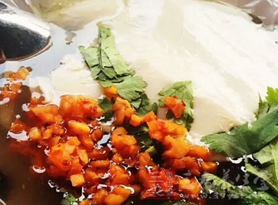 用勺子舀了一碗豆腐腦 用勺子舀了一碗豆腐腦