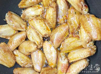 將腌好控干的雞翅刷一層蜜水,放置在烤盤的蔥,姜片上 將腌好控干的雞翅刷一層蜜水,放置在烤盤的蔥,姜片上