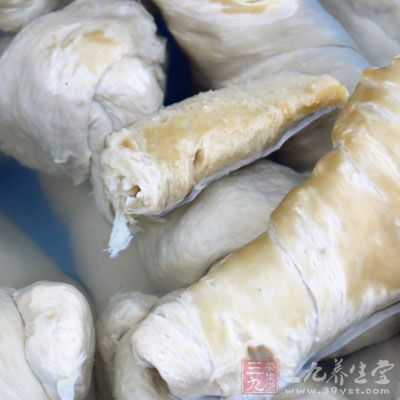 在盤上刷上油，將瀝淨水的面筋平鋪在盤上