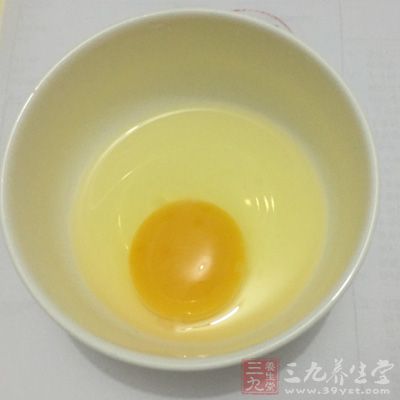 把雞蛋磕到碗裡，加入精鹽、味精拌勻