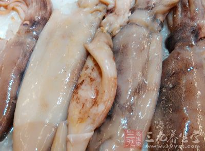 將整條新鮮鱿魚從側面用刀剖開，在案板上展平