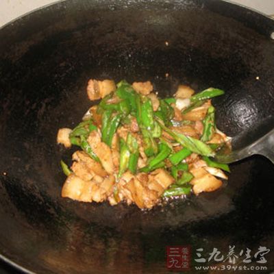 等到辣椒炒至表皮有點快糊的時候，下肉一起炒勻