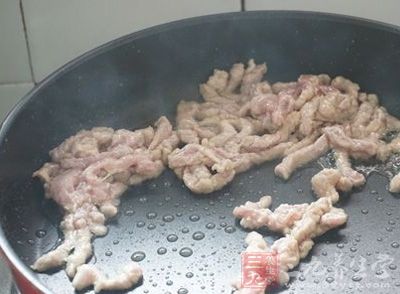 待肉絲變色後用鏟子撥到鍋邊