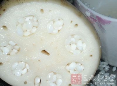 從切口處塞入糯米。每塞一把就用筷子捅一下，直到填滿
