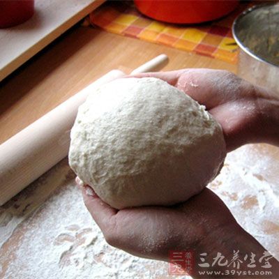 發好的面團從盆中拿出來，揉勻鹼面