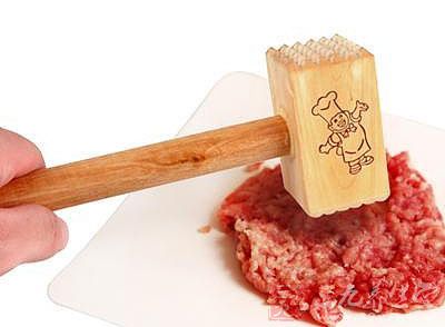 將大排放平，用肉錘將大排上的肉剁松軟