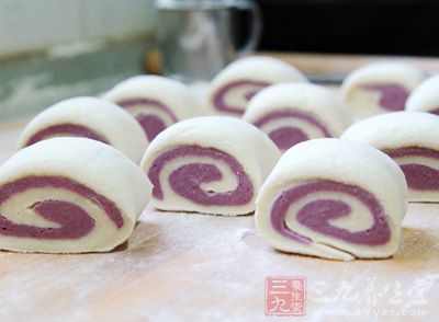把紫薯面和南瓜面分別擀成四方形疊在一起卷成卷，切成適合大小