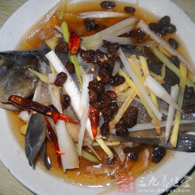 將蔥絲、紅椒絲放在魚身上，澆上蒸魚豉油