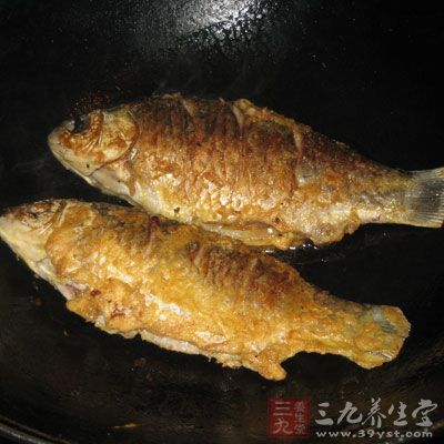 將煎好的魚頭朝外尾朝內轉圈擺在蔥姜等調料上，為第一層