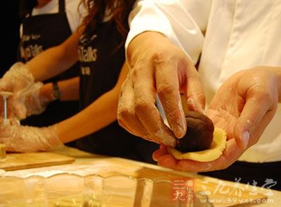 包月餅，手掌放一份月餅皮，兩手壓壓平，上面放一份月餅餡
