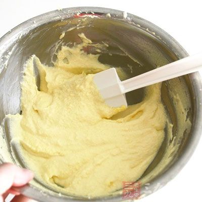 打散的雞蛋黃分次加入打發的淡奶油攪拌均勻。加入煉奶