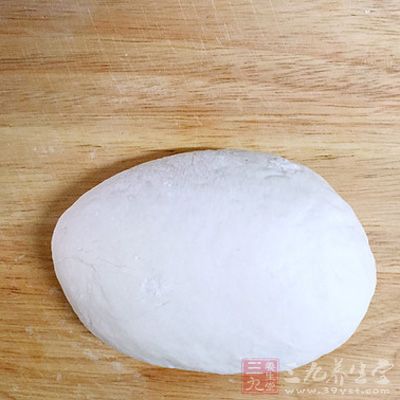 饧半小時後的面團，放在案板上，要用力揉制，直到揉勻、揉軟、揉光