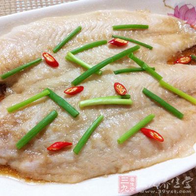 龍利魚盤底墊蔥段，放上魚，再放姜片