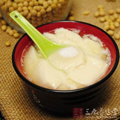 用勺子舀了一碗豆腐腦 用勺子舀了一碗豆腐腦