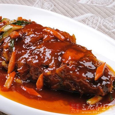 鍋中放油燒至七成熱，手提魚尾放入油鍋內