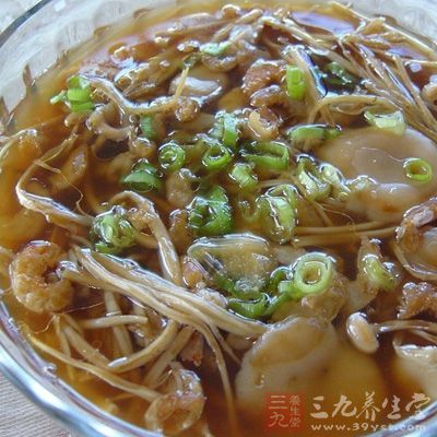 鍋裡加清水，加入姜片，大火煮開後放入豆腐和金針菇