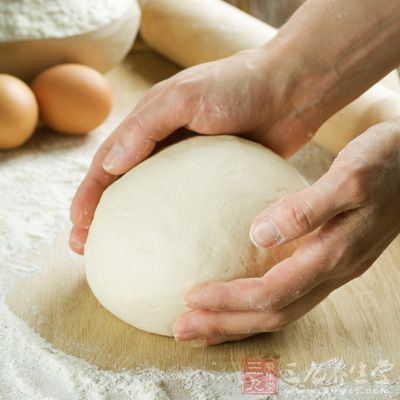 取一塊面團,壓扁,從中間往下擀 取一塊面團,壓扁,從中間往下擀